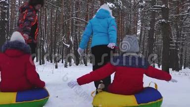 带着孩子的家庭在圣诞假期放松，同时骑着雪萨瑟和笑。 爸爸妈妈和女儿骑着车